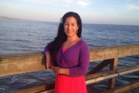 woman in purple shirt standing on pier by ocean