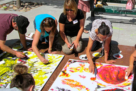 educators working on large art canvases on the ground together