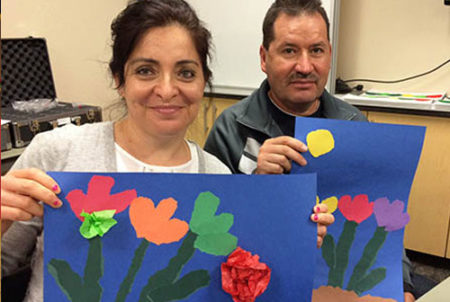 two adults holding art with flowers