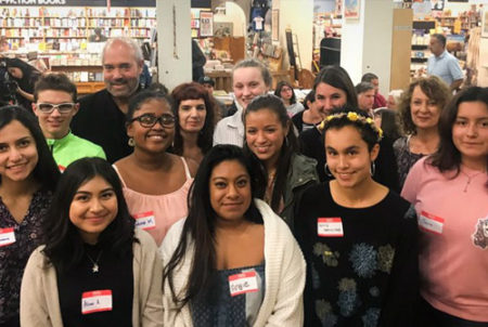 smiling adults and students with name tags at book store