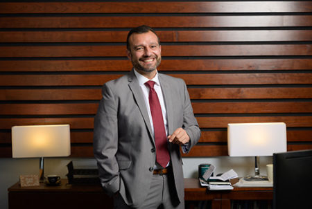 man in suit standing in front of desk