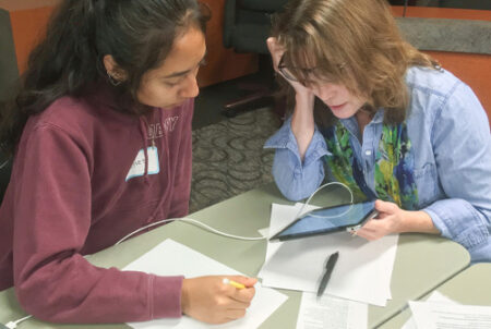 Teacher helping student in essay workshop